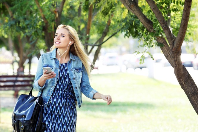 Een vrouw die naar een podcast luistert. Beeld: Shutterstock